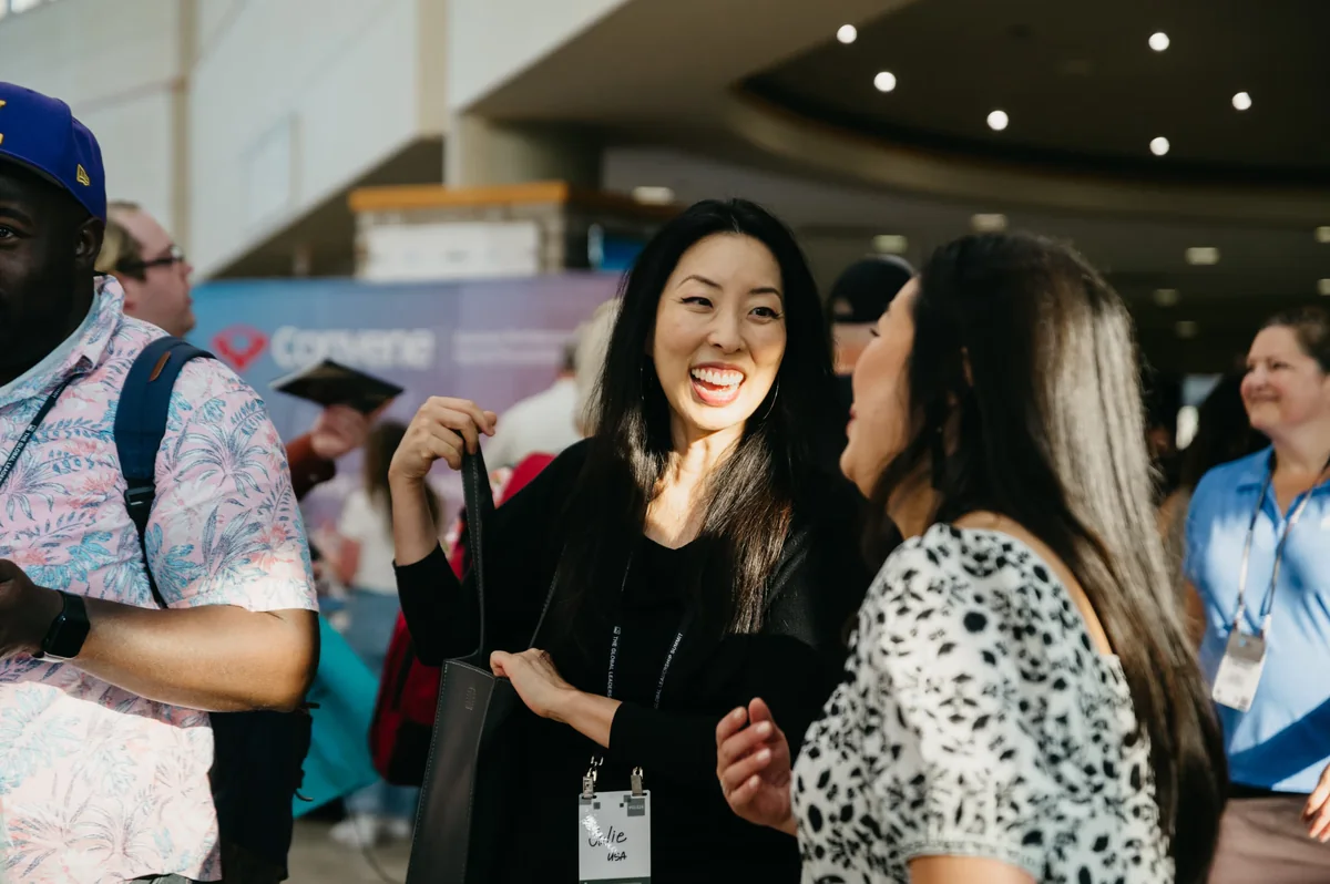 Summit attendees chatting in a busy event foyer
